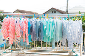 Baby Clothing on a clothesline. Dry clothes in bright colors in the sun. Clothesline with hanging baby clothes.