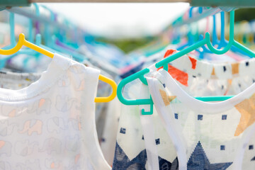 Baby Clothing on a clothesline. Dry clothes in bright colors in the sun. Clothesline with hanging baby clothes.