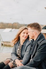 Young couple in love standing on the lake shore. Couple photos in spring. 