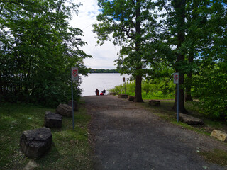 Two people sitting quietly near the river at the end of a path