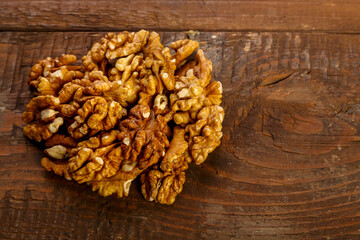 Walnuts are scattered on a dark wooden table.