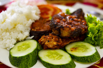 Com Tam - a close-up of Vietnamese cuisine: delicious broken rice with fried fish, cucumbers, salad. Delicious food - lunch.
