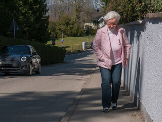 Modern senior woman walking up hill 
