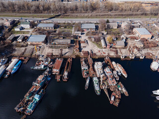 Aerial view of moored old barges and ships in river port