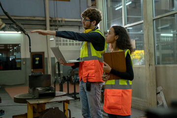 Two workers working together process in production line at metal manufacturing industry factory.