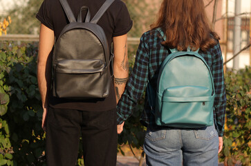 young man and young lady with backpacks, couple with  grey and blue backpacks
