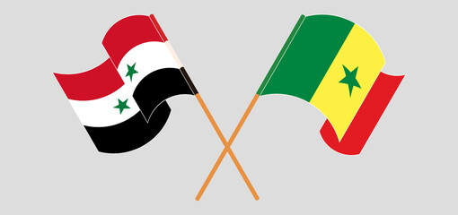 Crossed and waving flags of Syria and Senegal