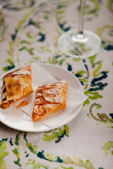 Italian food. Traditional sweet pastry made of sugar dough with jam filling in northern Italy in Salo, Lombardy region. Two pieces of cookies on a white plate on a table with a colorful tablecloth.