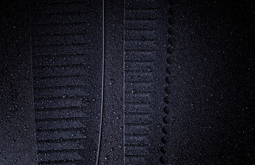 Chef's kitchen black knife blade close up on a black background. Water droplets on the knives.