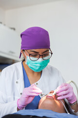 Dentist with glasses and mask during the patient's treatment in a dental office