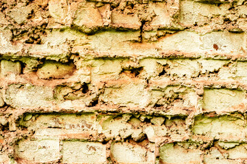 Fototapeta premium Texture of a brick wall with cracks and scratches which can be used as a background