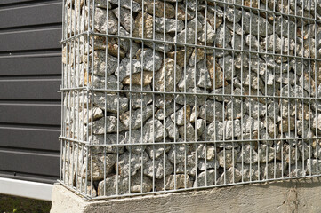 A fragment of the fence surrounding the property. Gabion wall.