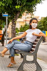 Young Azerbaijani Girl Wears White Face Mask, Sits on Bench in Street