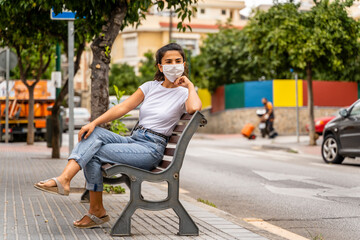 Young Azerbaijani Girl Wears White Face Mask, Sits on Bench in Street