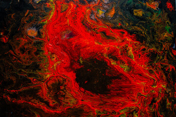 Texture in the style of fluid art. Abstract background with swirling paint effect. Liquid acrylic paint background. Red, black and yellow colors.