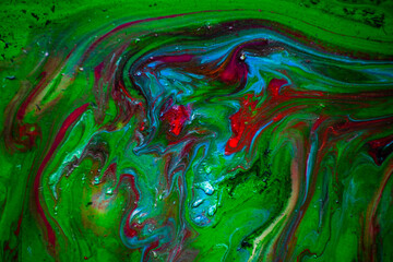 Texture in the style of fluid art. Abstract background with swirling paint effect. Liquid acrylic paint background. Green, blue and red colors.