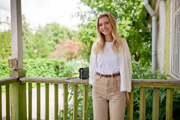Obraz premium Cute, young and beautiful girl with blue eyes in light clothes on the nature background. Smiling blonde girl.