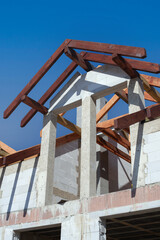 A new home under construction, detail. Light brick and wooden roofing beams