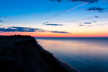 Fototapeta na wymiar Seascape before sunrise with the coast in the foreground.