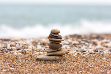 Stones are placed on top of each other on the background of the sea.	