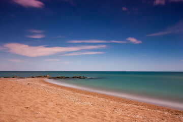 Sea landscape in the day with stones in the foreground.