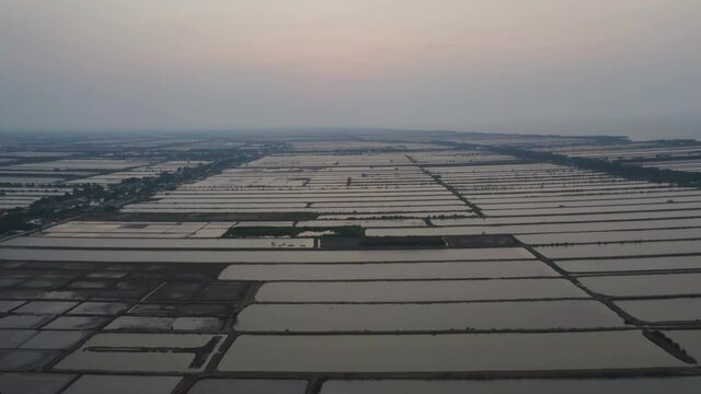 Aerial top view of natural sea salt ponds. Farm field outdoor. Material in traditional industry in Thailand. Asia culture. Agriculture irrigation. River reflection.