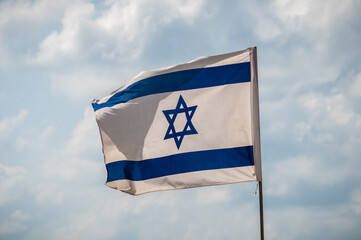 Flag of israel in the wind with clouds background independence day
