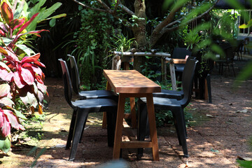 chair and table on a sun terrace. wooden garden old painted benches and table,beautiful picnic area with wooden table and blooming rhododendrons,chair in green garden terrace , Home lifestyle