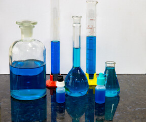 Chemical laboratory material with test tubes, colored conductors, blue, laboratory glassware, test tube, on dark surface with reflection and dark background.Selective focus