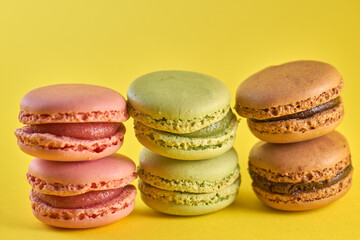 Cake macaron close up on yellow background flavor almond cookies pastel colors.