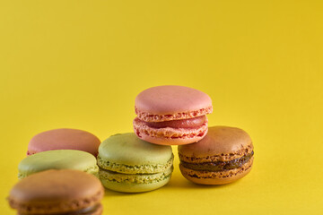 Cake macaron close up on yellow background flavor almond cookies pastel colors.