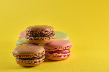 Cake macaron close up on yellow background flavor almond cookies pastel colors.