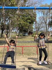 公園のブランコで元気に遊ぶ子供