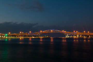 Fototapeta na wymiar Blue Water Bridge At Night Lights Up The St. Clair River Waterfront