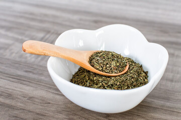 Close up of wooden spoon with basil.