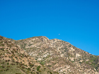 Paraglider seen from Old Romero Canyon Trail in Montecito, California near Santa Barbara on a clear, sunny spring day