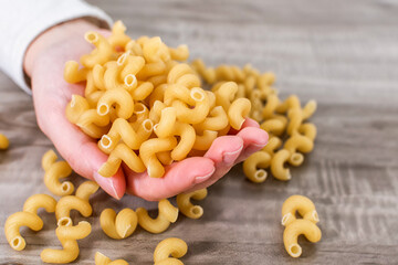 Close-up of human hand holding macaroni.