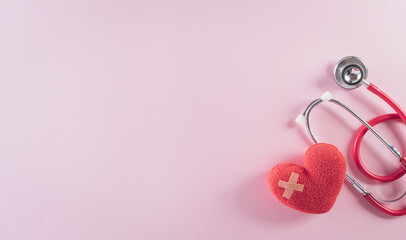 Top view of doctor stethoscope and red heart on pastel background. World health day and medical concept.