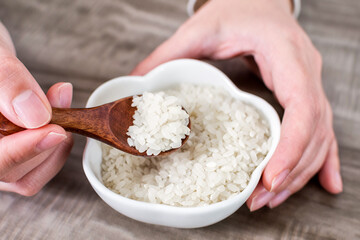 Close up of wooden spoon with rice grains.