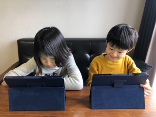 タブレットでオンライン授業を受ける子供