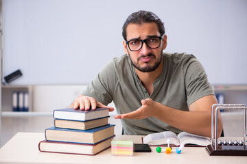 Young male student preparing for exams in the classroom