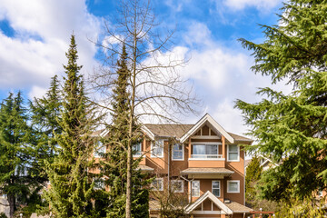 A perfect neighborhood. Houses in suburb at Summer in the north America. Top of a luxury house with nice window over blue sky.