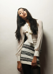 Young asian fashionable woman wearing white dress posing over white background