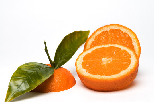 Cut Orange fruit with leaves isolated on white. © SimoneO