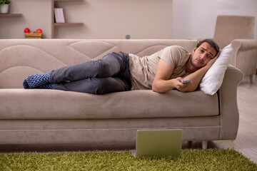 Young man lying on the sofa at home