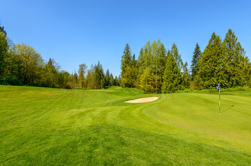 Fototapeta na wymiar Golf course with gorgeous green and sand bunker