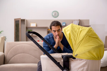 Young male contractor looking after baby at home