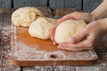 Empty space for text. Hands holding dough on the rustic table.