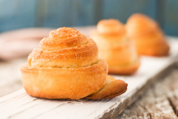 Fresh sweet cinnamon rolls. Rustic table.