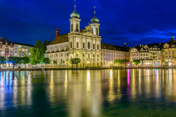Fototapeta na wymiar Night view towards Chapel Bridge (Kapellbruecke) together with the octagonal tall tower (Wasserturm) it is one of the Lucerne's most famous tourists attraction